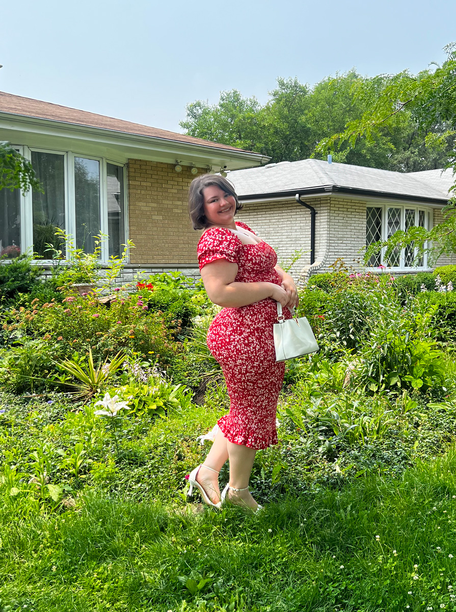 Coach is a garden, posing for a photo weeatring flower dress.